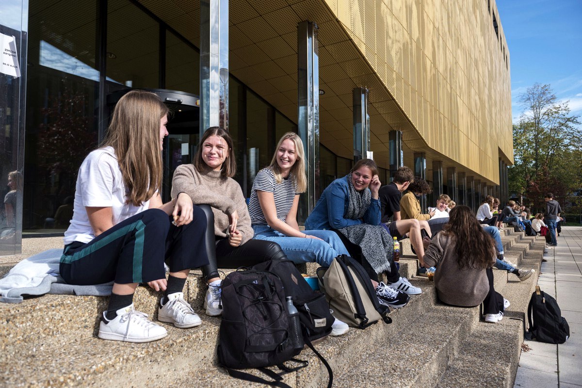 Readers talking together outside a modern public building in daylight.